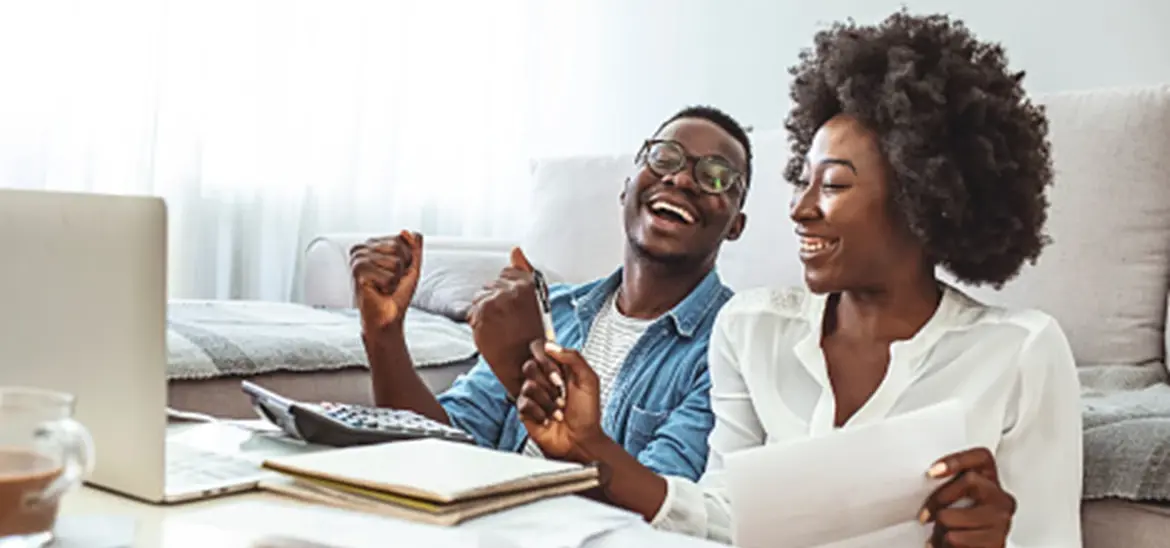 A happy couple cheering while reviewing paperwork