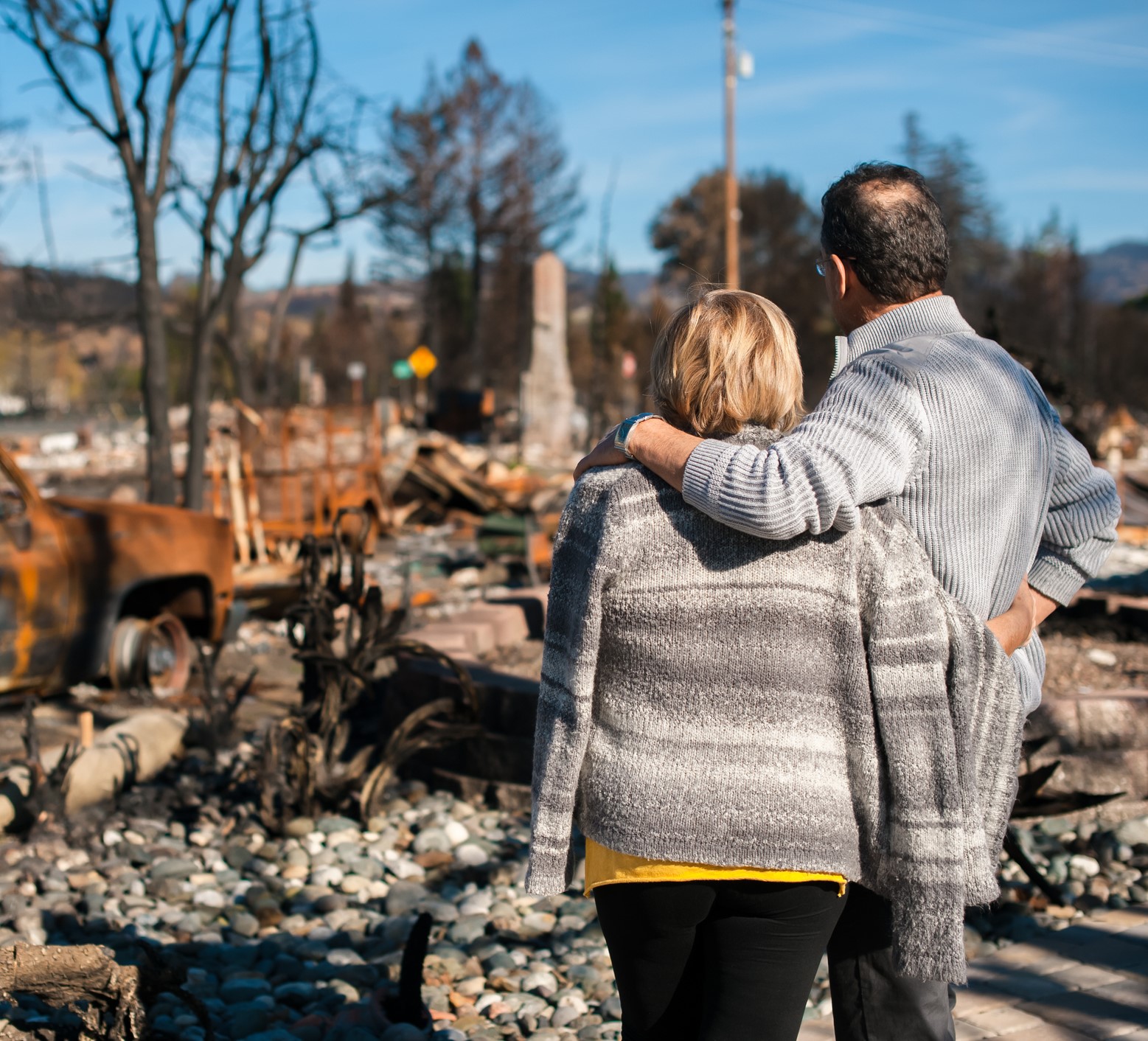 A couple looking at the aftermath of a fire