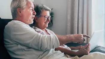 A senior couple looking at a laptop together