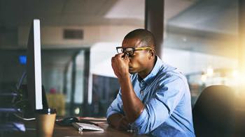 Distressed man looking at computer screen