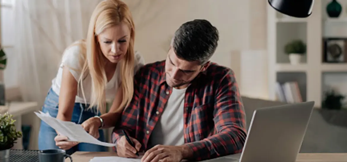 A couple carefully reviewing and signing paperwork